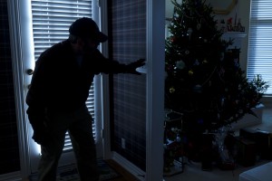 This photo illustrates a burglary or thief breaking into a home at night through a back door during the Christmas Holiday Season. View from inside the residence.